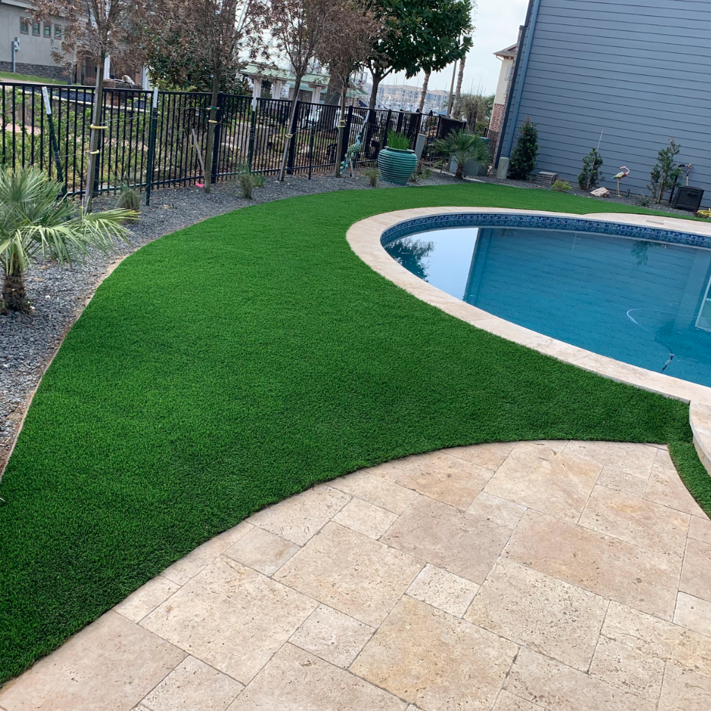 Turnkey artificial turf installation around a pool area with smooth curves and clean edges, completed by Sermons Turf Installs in South Houston.