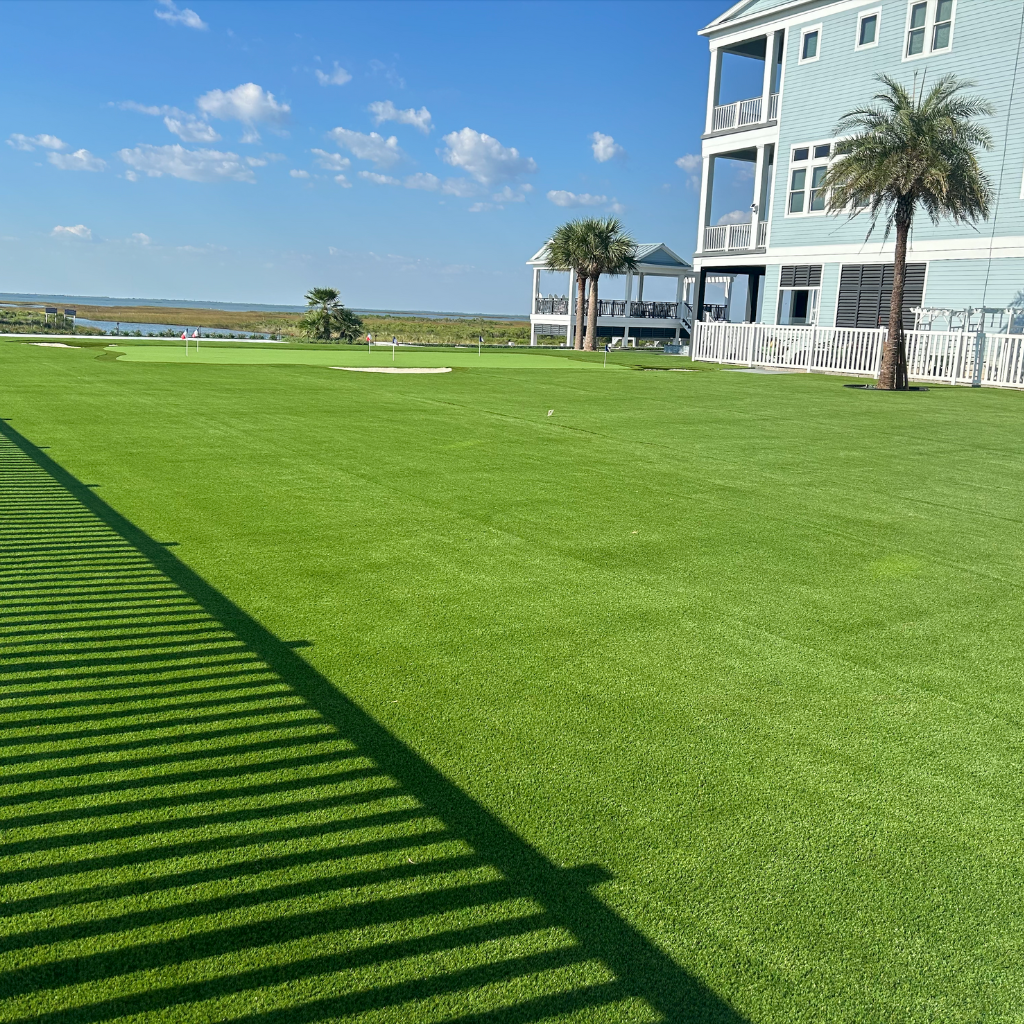 Expansive side yard lawn with a custom putting green, overlooking Galveston Bay, installed by Sermons Turf Installs.
