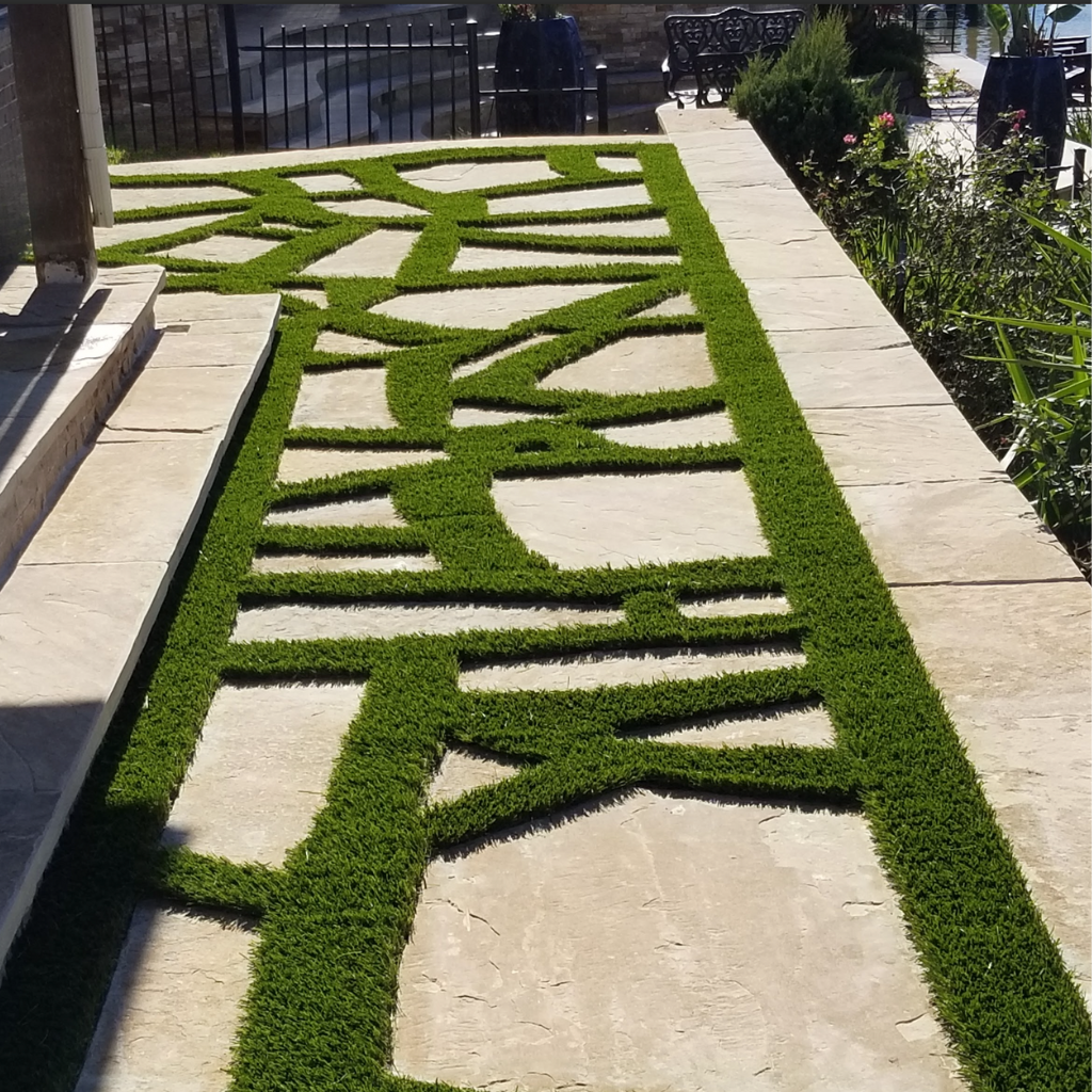 Free-form paver design with artificial turf accents, creating a unique and artistic pathway.