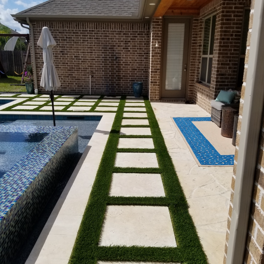 Poolside walkway with square pavers and artificial turf in South Houston, TX.