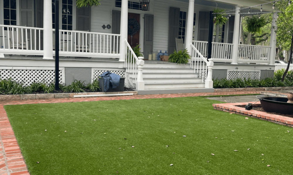 In South Houston, a front porch with a brick pathway and a luxury artificial turf lawn installation, completed by Sermons Turf Installs.