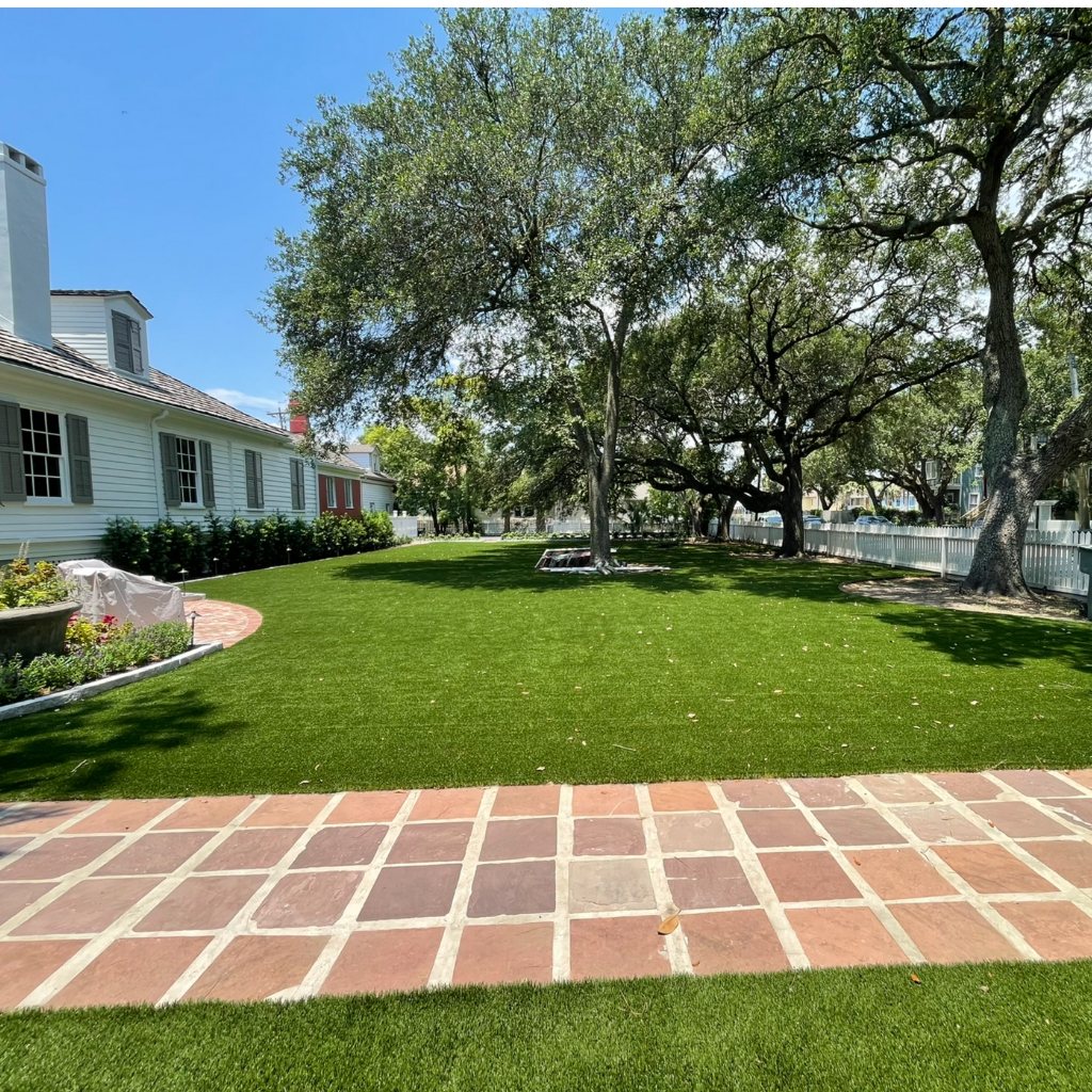 Expansive artificial turf lawn with large trees and pavers, installed by Sermons Turf Installs.