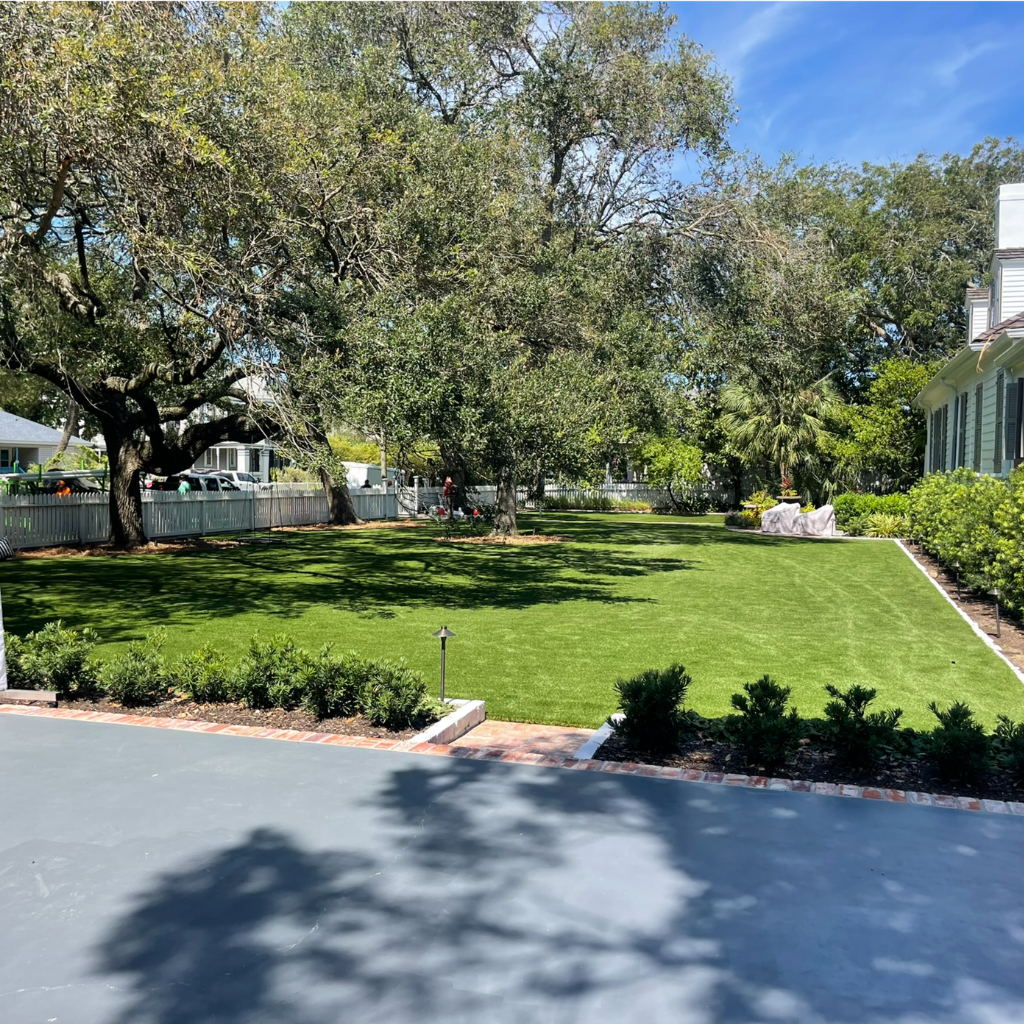 A spacious, shaded luxury lawn with artificial turf installed by Sermons Turf Installs.